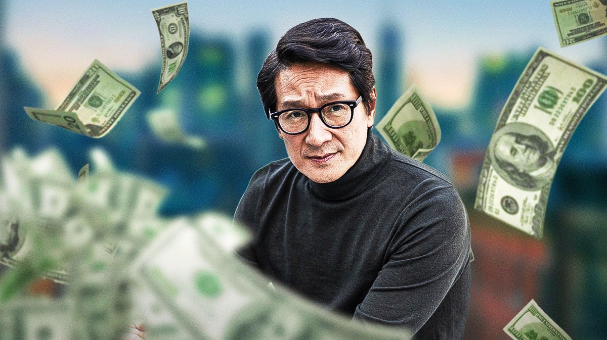 Ke Huy Quan surrounded by piles of cash.