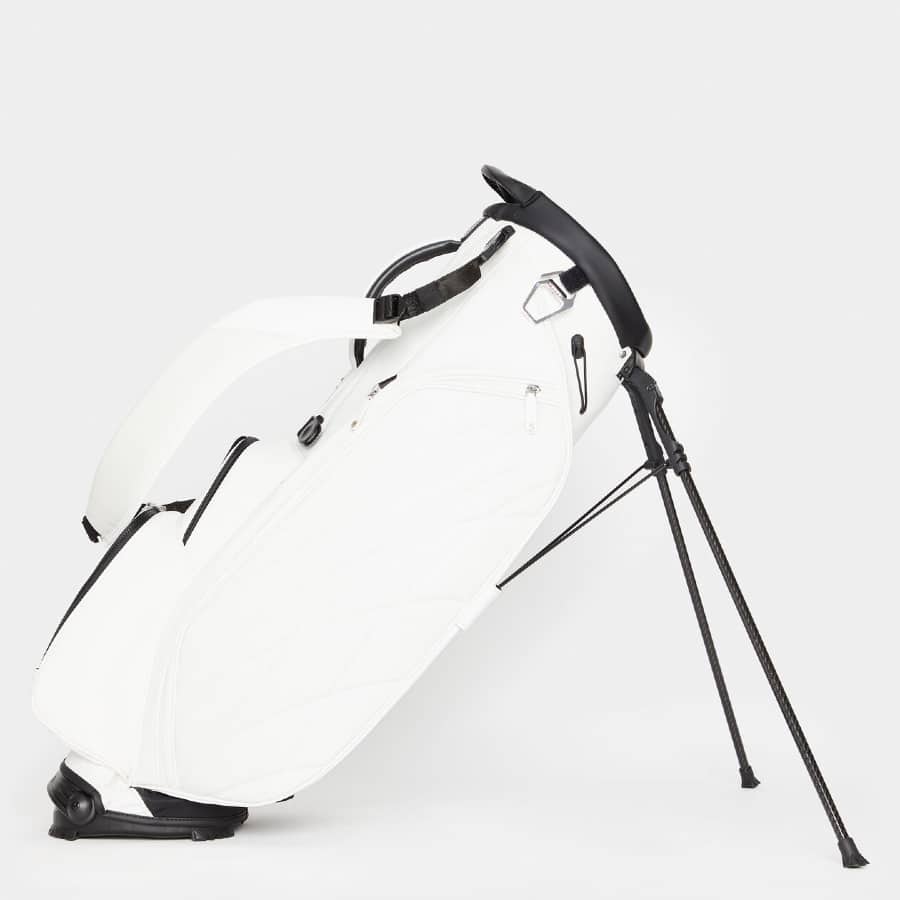 White colored G Fore transporter golf bag on a grey background.