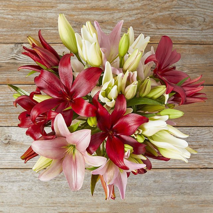 The Bouqs Co. Mother's Day lilies arrangement on a wooden table.