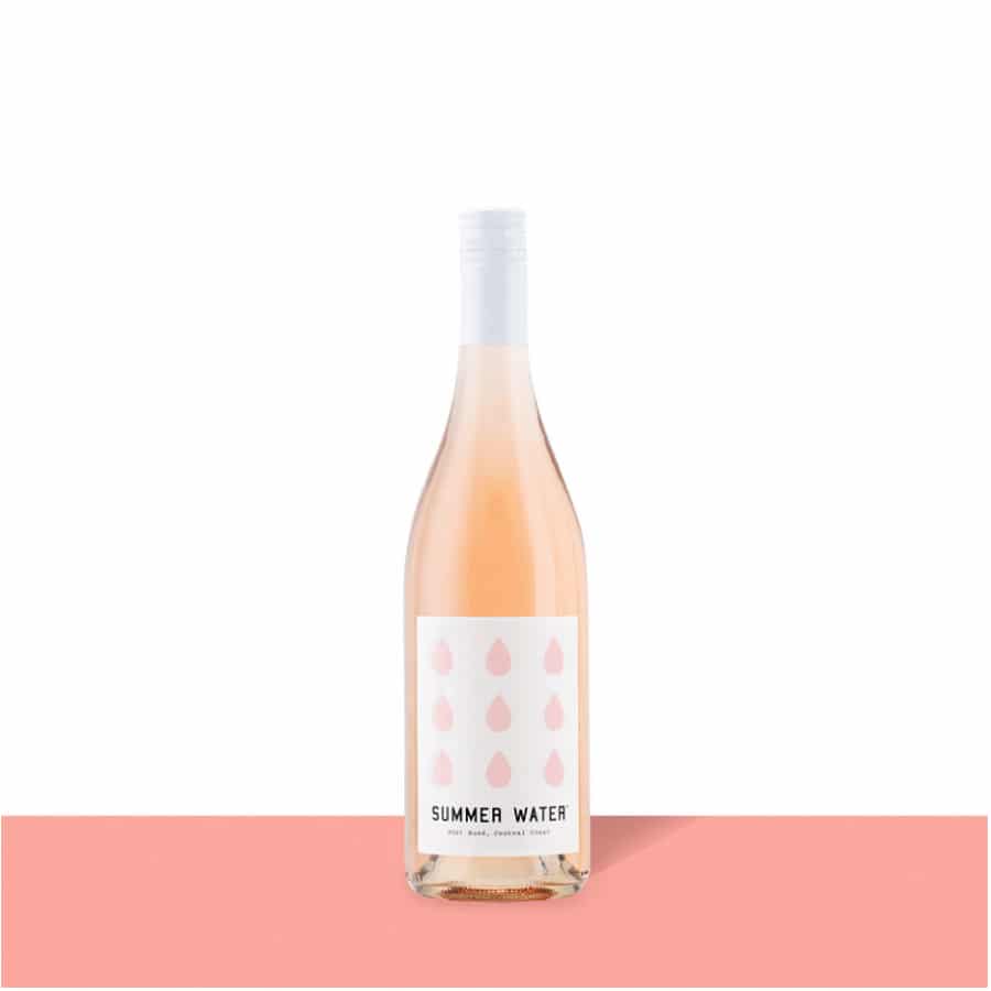 Winc 2021 Summer Water - Rosé wine bottle on a pink display table.
