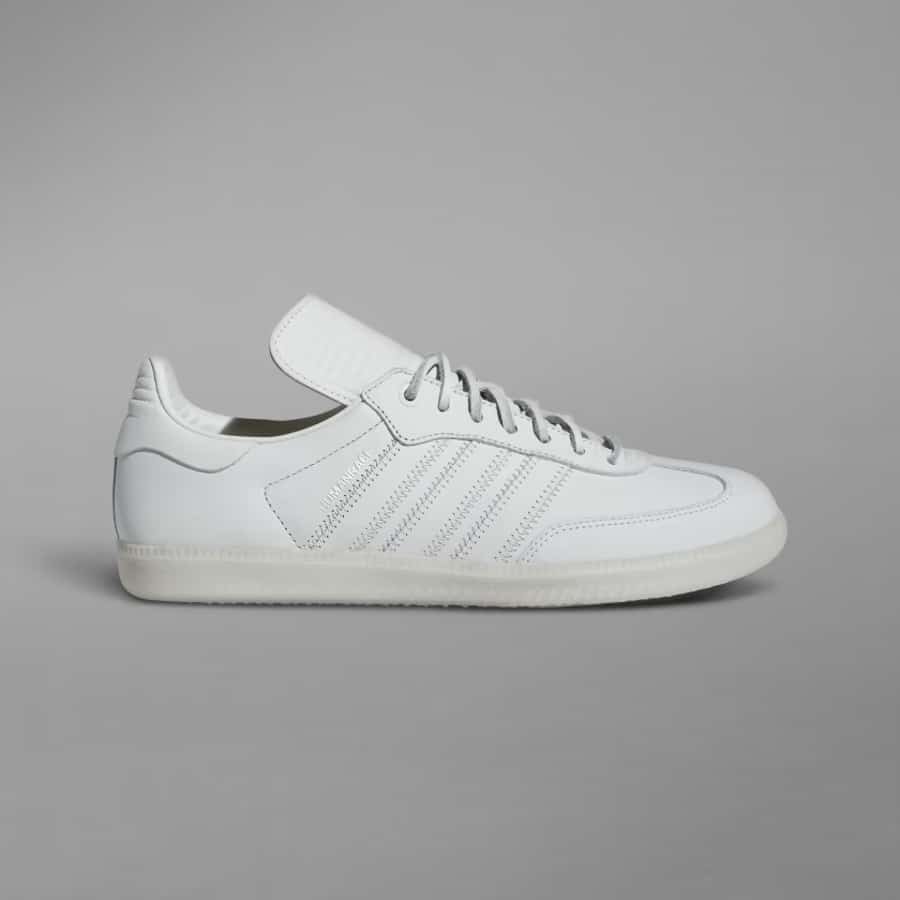 Adidas Humanrace x Samba Shoes - White/White/White on a dark gray background. 