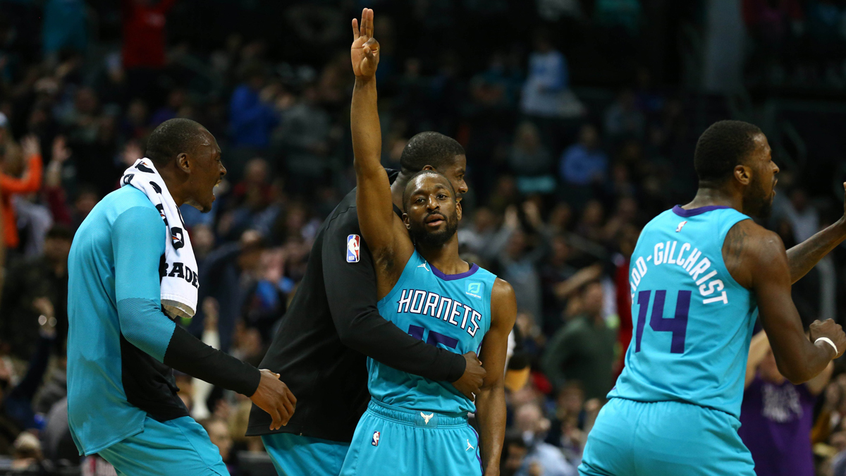 Charlotte Hornets guard Kemba Walker (15) reacts to a three point basket while being hugged by forward Marvin Williams (2) in the second half against the Brooklyn Nets at Spectrum Center.