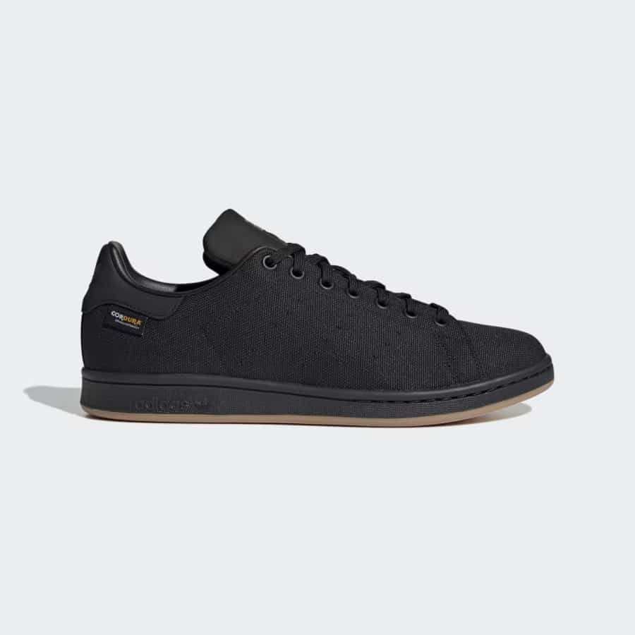 Adidas Originals Stan Smith - Core Black/Carbon/Gum colorway on a light gray background. 