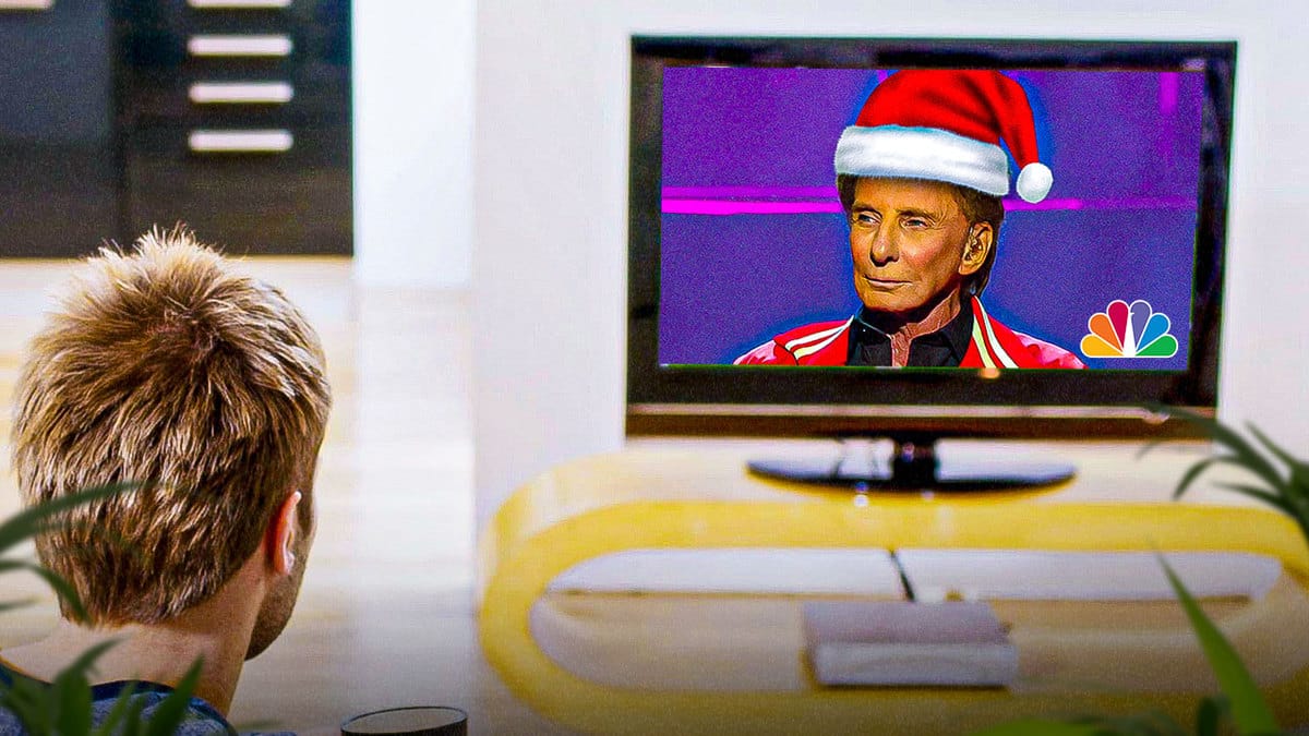 Barry Manilow on NBC TV wearing a Santa hat with viewer watching him.