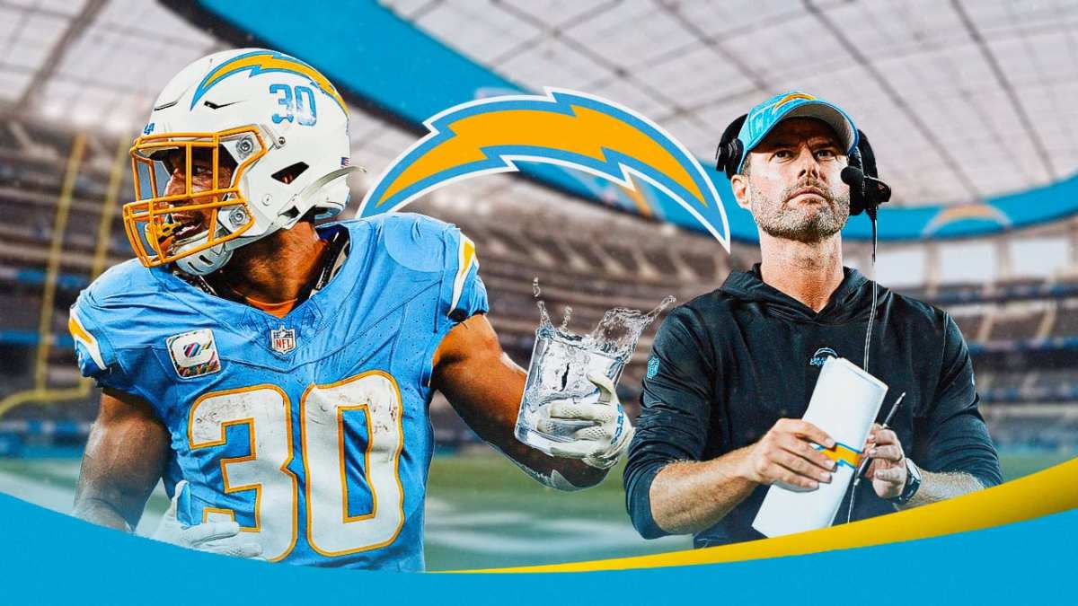 Austin Ekeler pouring out a glass of water while head coach Brandon Staley watches