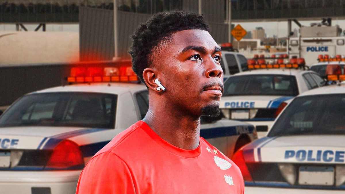 Justyn Ross looking serious with police car in the background