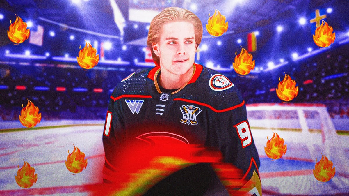 Image: Leo Carlsson in image looking happy with fire around him, ANA Ducks logo, hockey rink in background