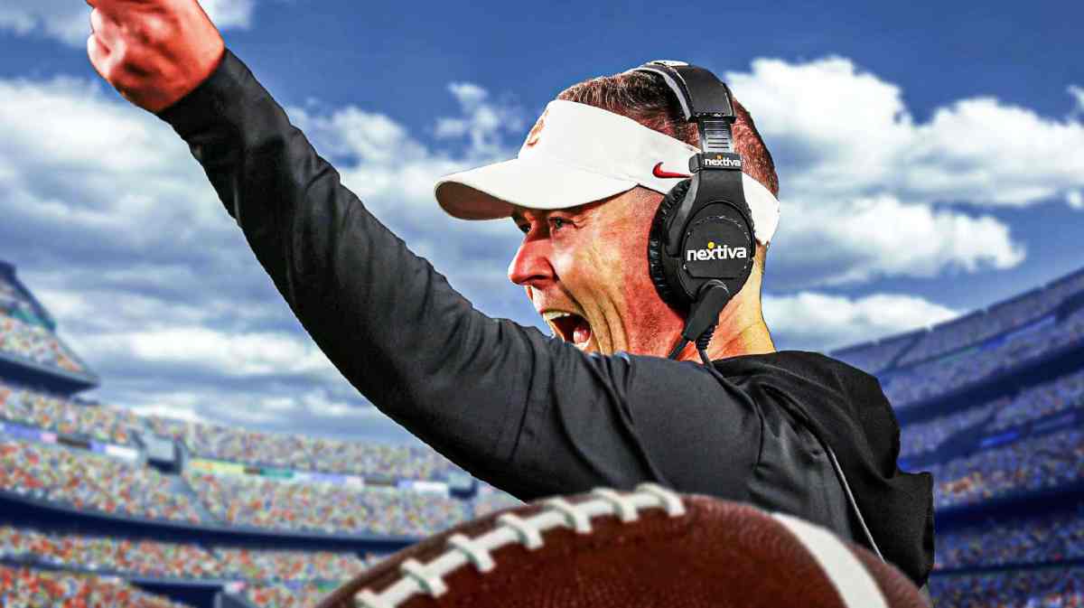 Lincoln Riley shouts out a play with a football field in the background.