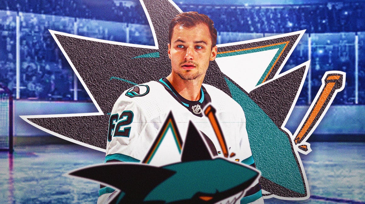 Kevin Labanc in middle of image looking stern, SJ Sharks logo in image, hockey rink in background