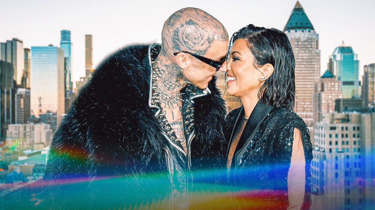 Travis Barker and Kourtney Kardashian smiling at each other.