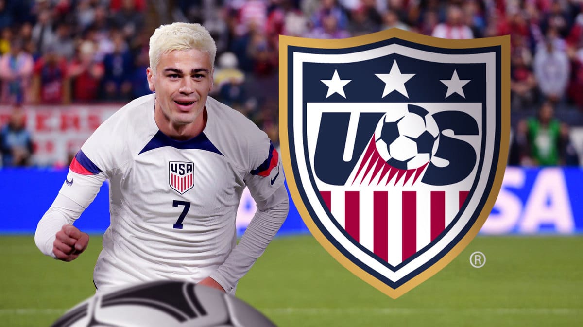 Gio Reyna celebrating in front of the USMNT logo