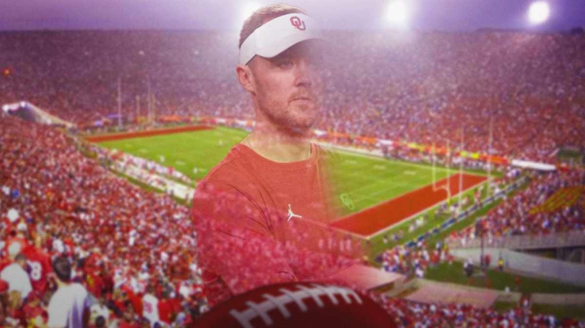 USC football coach Lincoln Riley seems to disappear with the football field in the background.