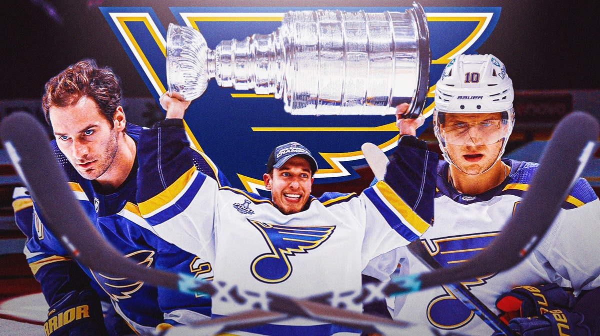 Jordan Binnington in middle looking happy, Brandon Saad and Brayden Schenn on either side looking stern, STL Blues logo in image, hockey rink in background