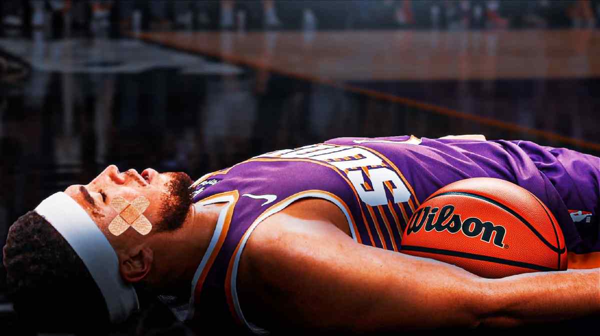 Phoenix Suns guard Devin Booker lies on the ground with bandage on head.