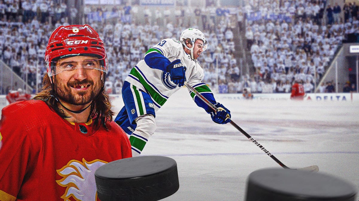 Chris Tanev smiling next to Quinn Hughes