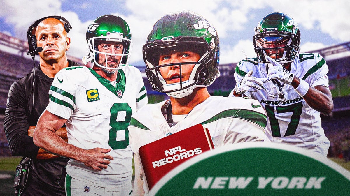 Jets' Zach Wilson holding an NFL record book surrounded by Aaron Rodgers, Garrett Wilson, Robert Saleh