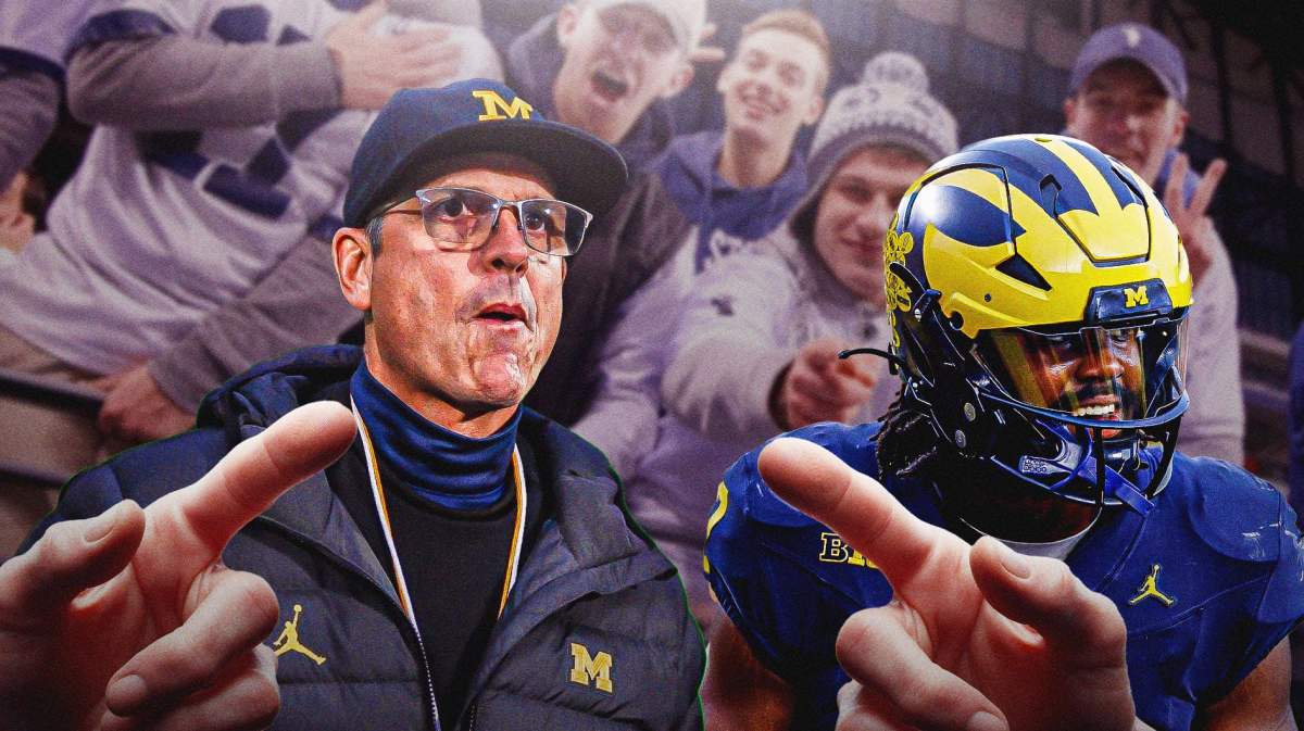 Michigan coach Jim Harbaugh and Michigan player in foreground. In background, Penn State fans laughing and pointing fingers at Michigan coach and player.