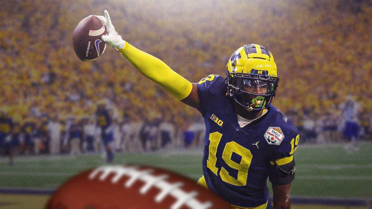 Michigan football player Rod Moore holding a football.