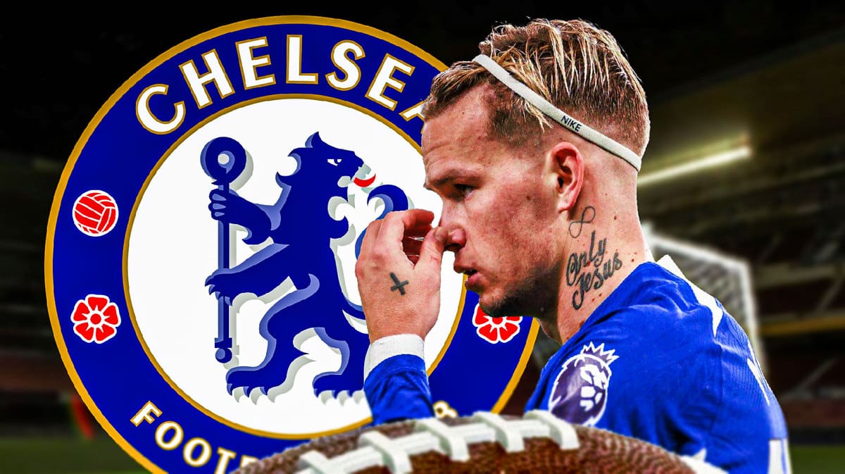 Mykhailo Mudryk looking down/sad in front of the Chelsea logo