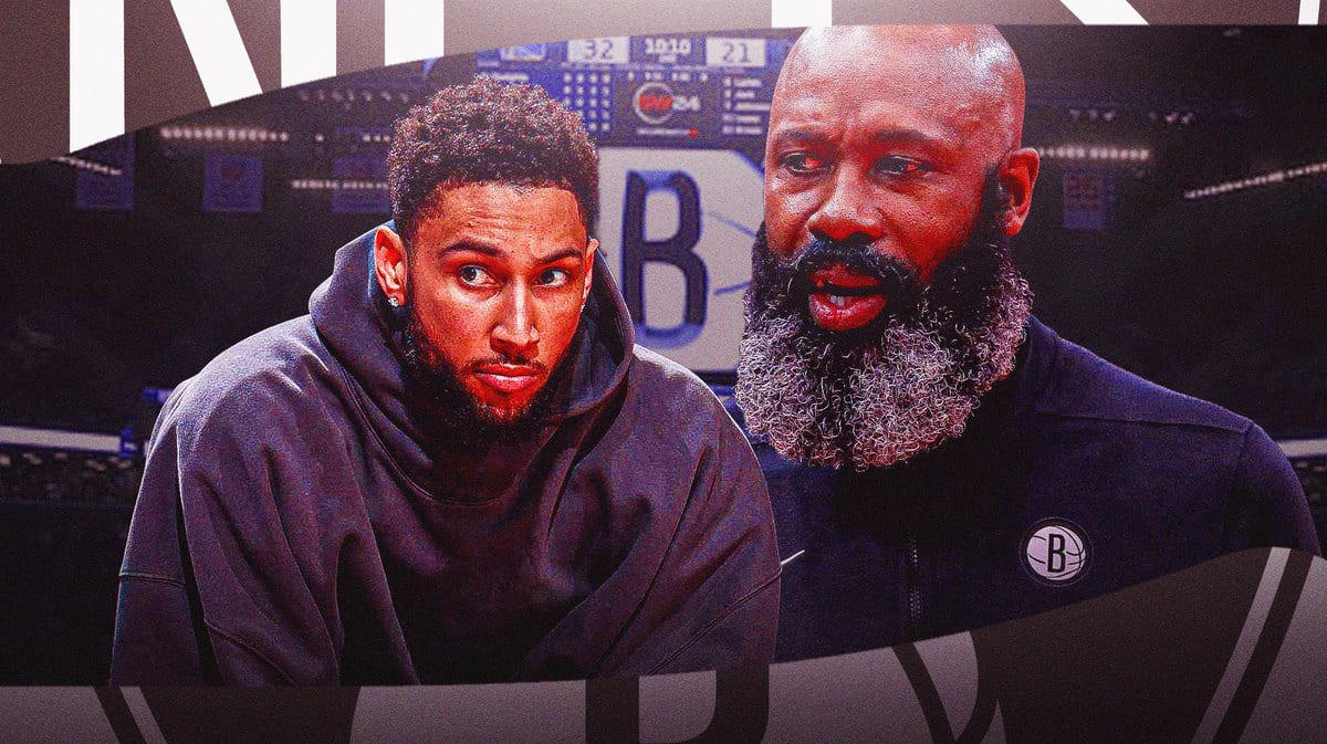 Nets' Ben Simmons sitting down on an NBA sideline. Nets' Jacque Vaughn in background.
