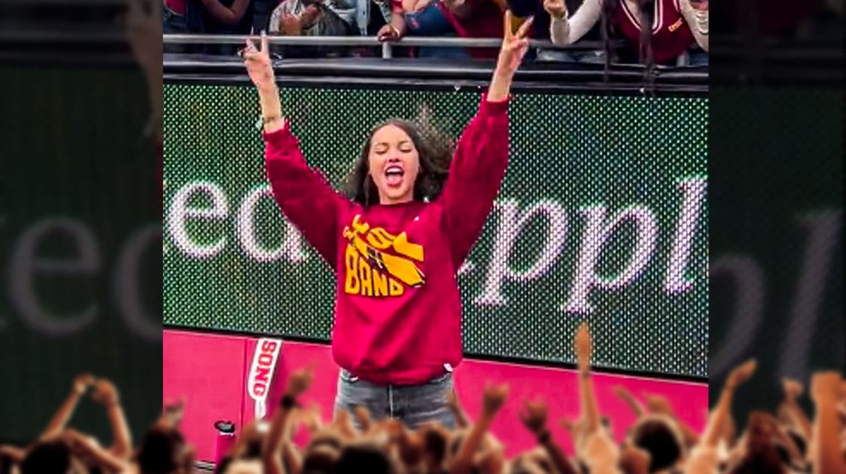 Viral clip of Olivia Rodrigo flashing the "fight on" signal and celebrating on the sideline in a USC band sweatshirt