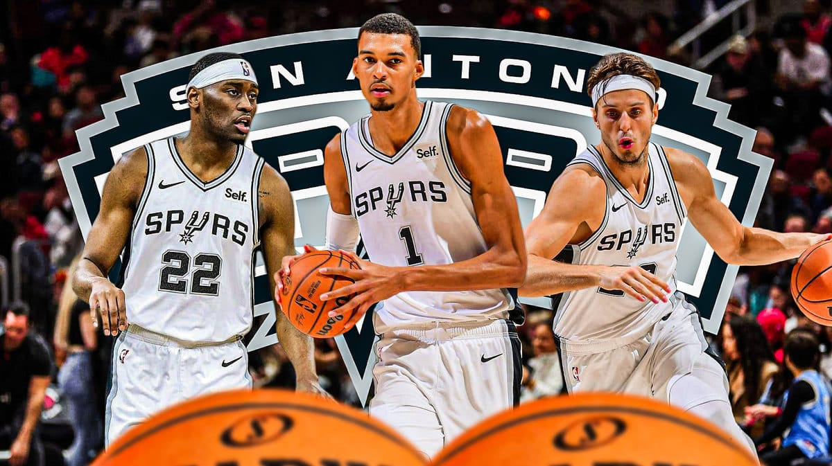 Victor Wembanyama in middle, Malaki Branham and Zach Collins on either side, Spurs logo and basketball court in background