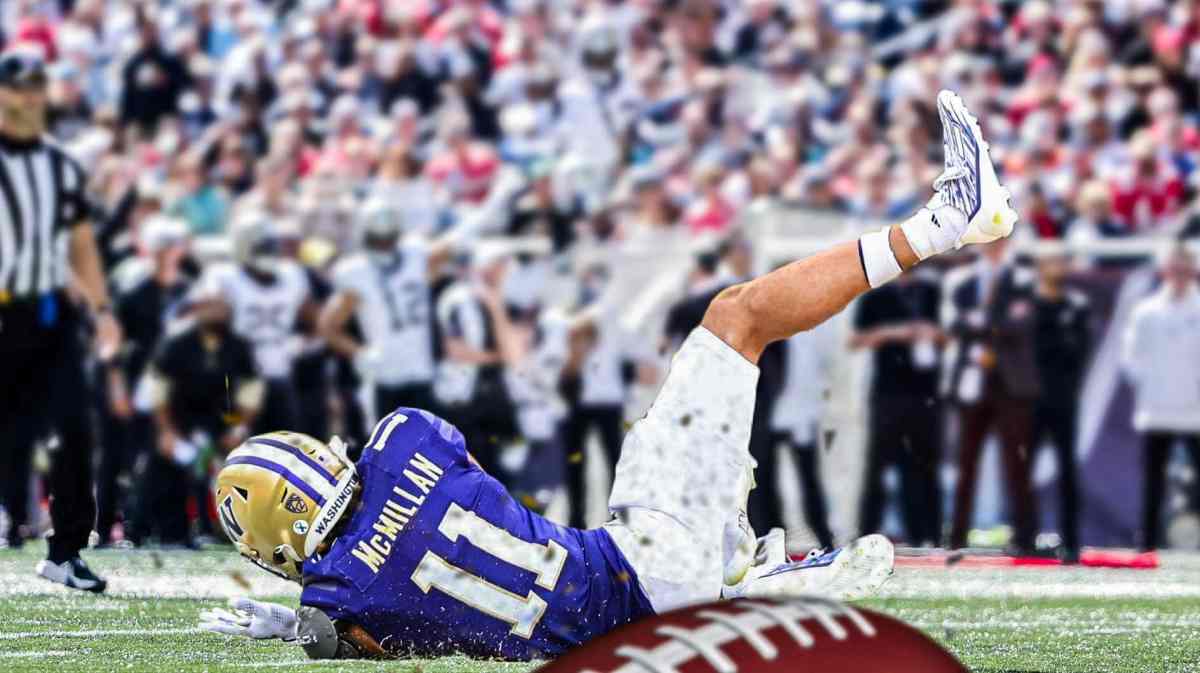Washington's Jalen McMillan falls to ground injured with fans watching in background.