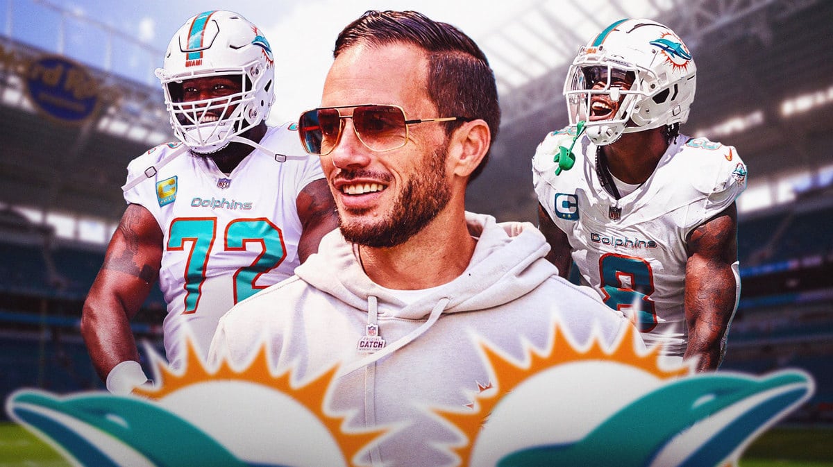 Mike McDaniel smiling with Terron Armstead and Jevon Holland on either side of him - Dolphins