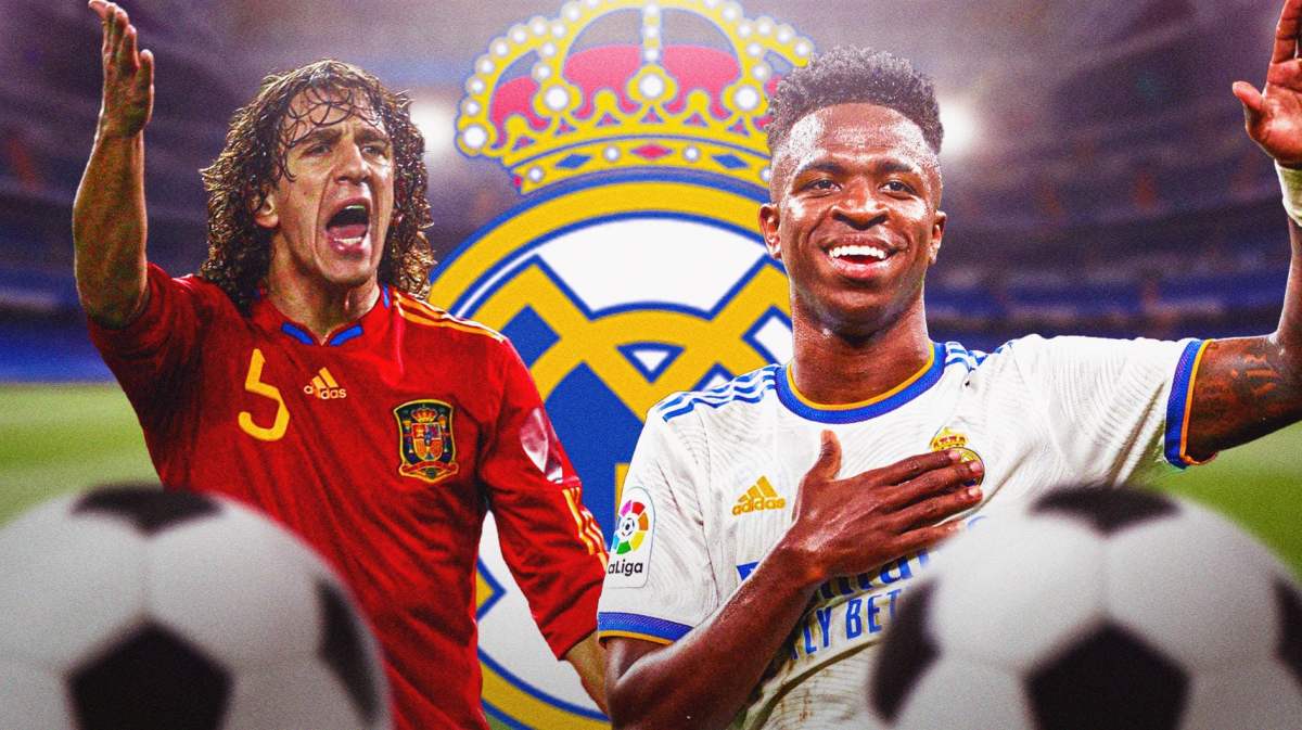 Carles Puyol and Vinicius Jr. in front of the Real Madrid logo