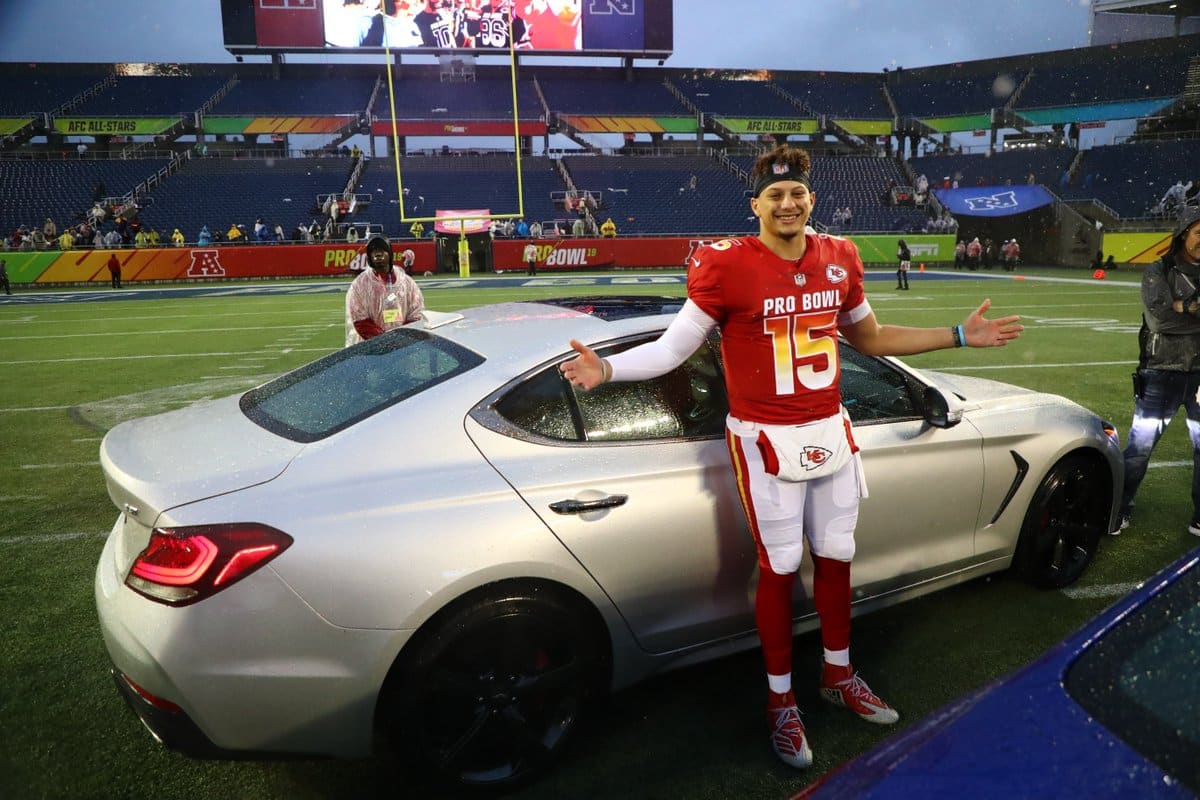 Kansas City Chiefs quarterback Patrick Mahomes in front of the car he won for being the Pro Bowl MVP.