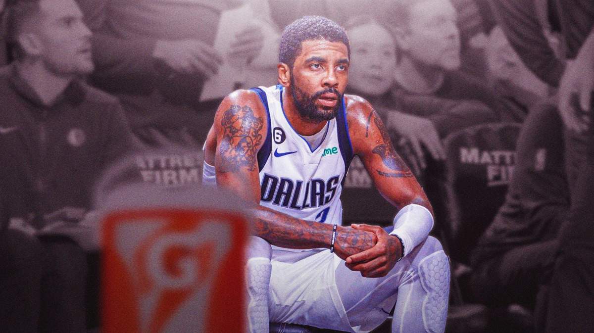 Mavs' Kyrie Irving sitting on an NBA bench looking serious