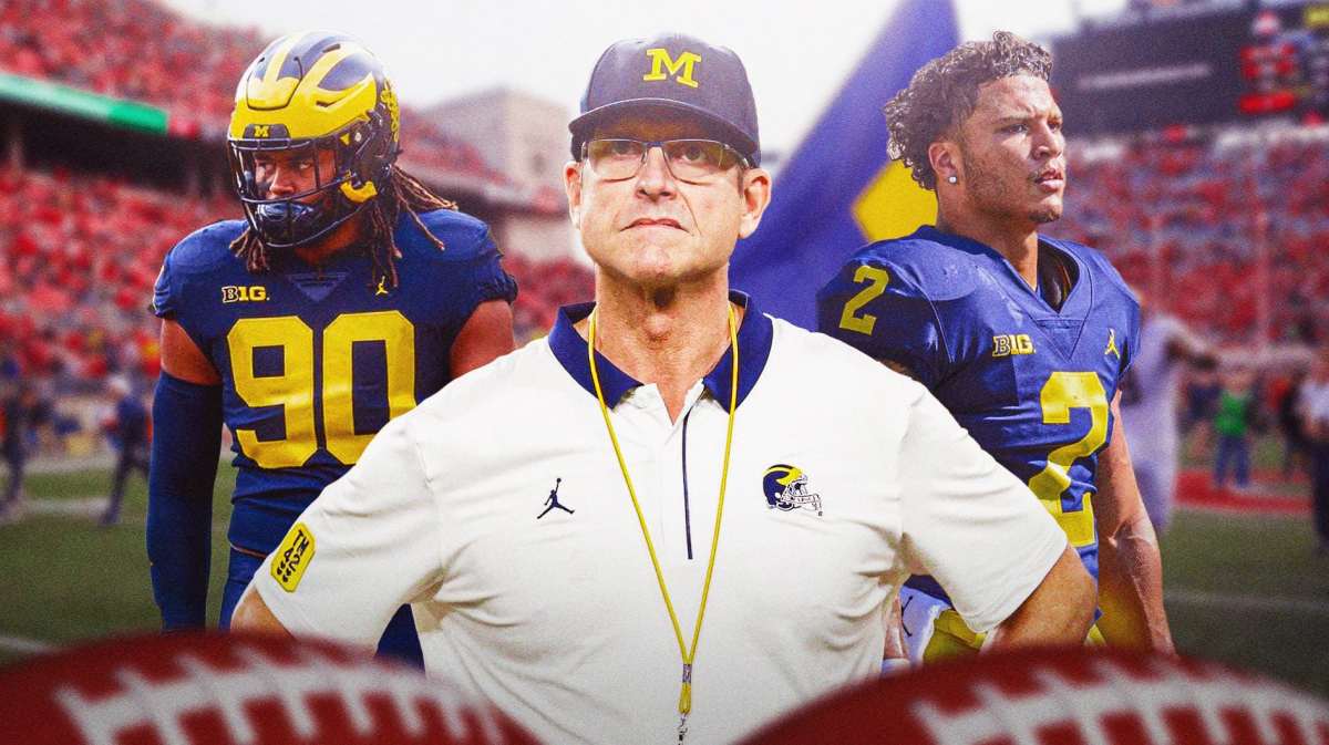 Michigan coach Jim Harbaugh in the foreground looking somber. Players are behind him looking somber too.