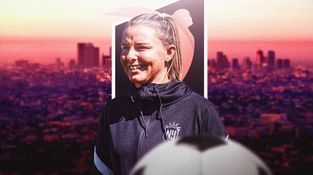 NWSL Angel City coach Becki Tweed in foreground and a faded Angel City FC logo behind Tweed.