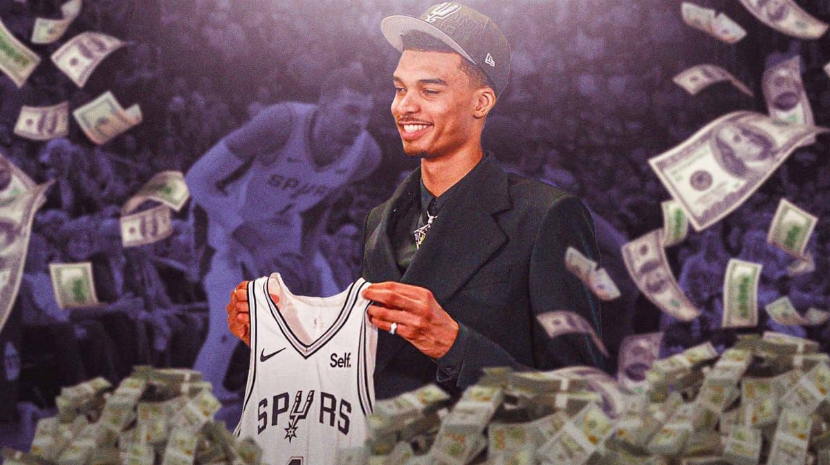 Victor Wembanyama holding up his Spurs jersey Cash flowing from the bottom of the screen
