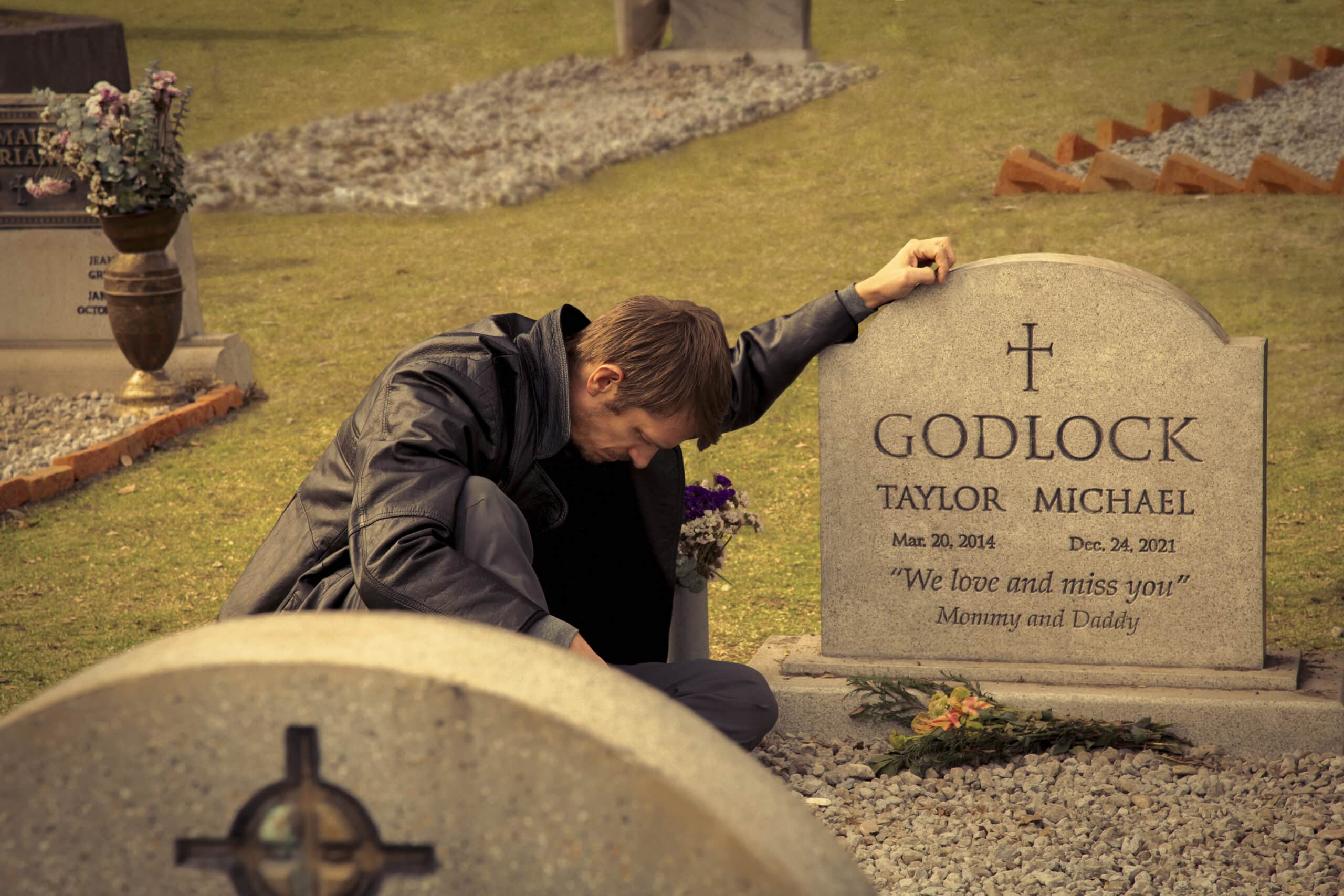 Joel Kinnaman next to grave.