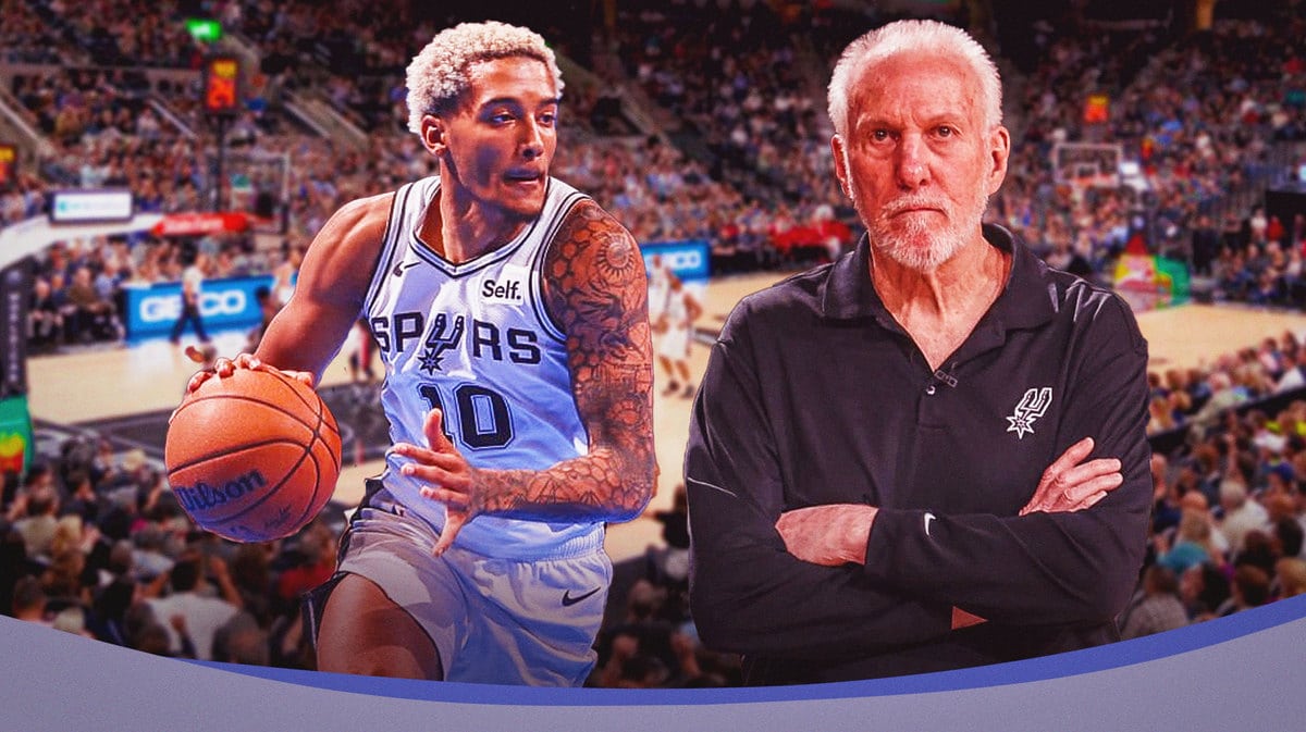 Spurs' Jeremy Sochan dribbling a basketball. Spurs' Gregg Popovich in background