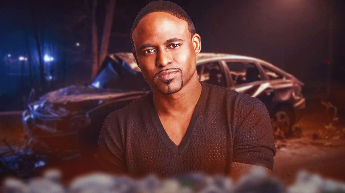 Wayne Brady with a car accident behind him.