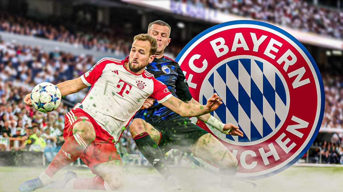 Harry Kane on the field againts a defender, the Bayern Munich logo behind him
