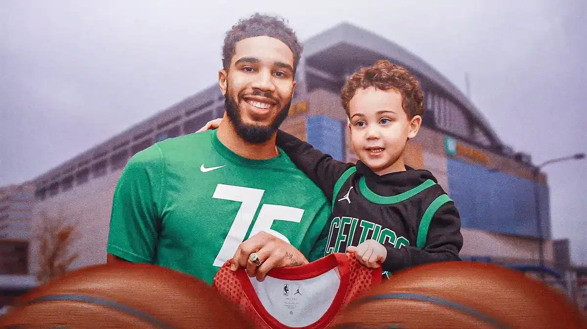 Jayson Tatum smiling next to his son deuce on a TD Garden background