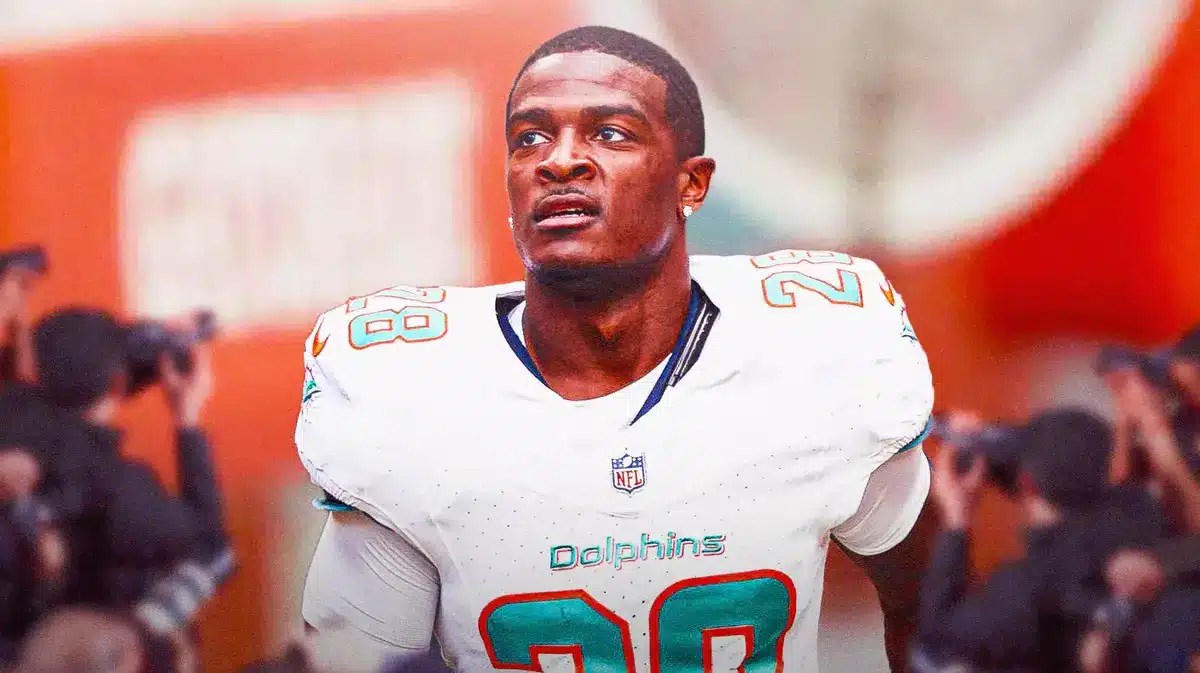 Dolphins' De’Von Achane sitting on an NFL sideline looking serious