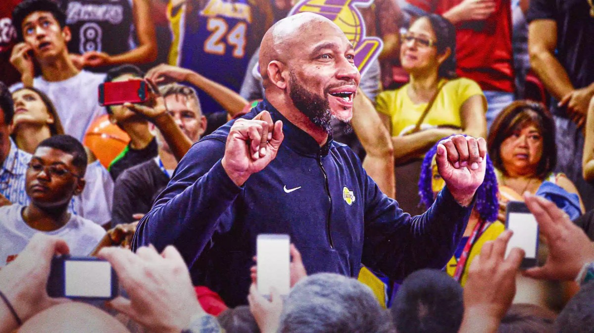 Lakers coach Darvin Ham celebrating in the foreground. Lakers fans in the background.