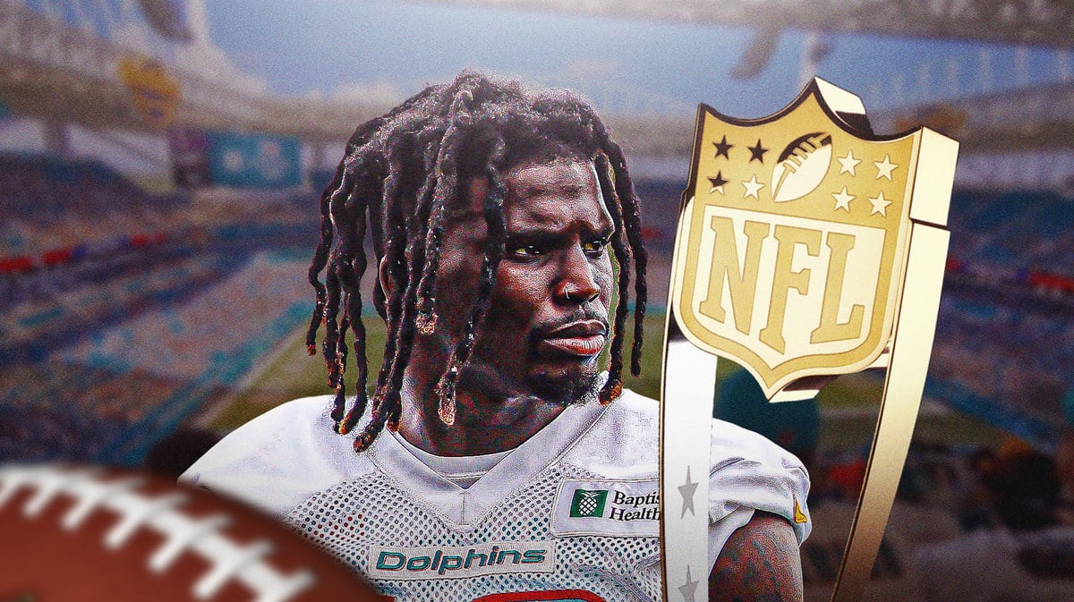 Miami Dolphins star Tyreek Hill next to the MVP trophy in front of Hard Rock Stadium.