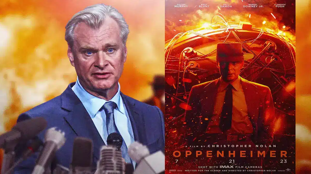 Christopher Nolan next to Oppenheimer poster.