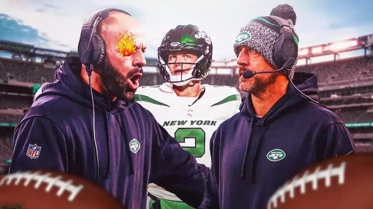 Robert Saleh with fire coming out of his eyes looking at Aaron Rodgers. Zach Wilson watching in background.