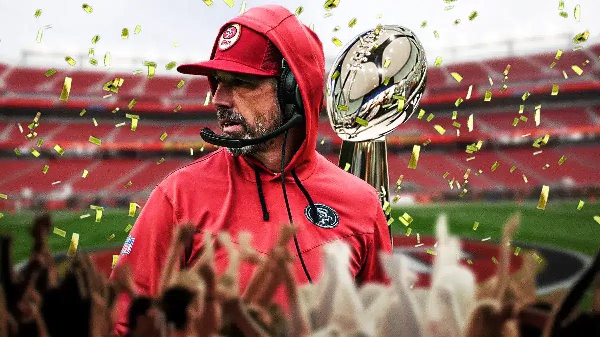 Photo: Kyle Shanahan with 49ers gear and Super Bowl trophy behind him with confetti falling