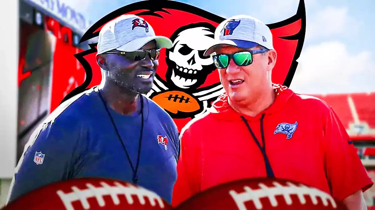 Buccaneers Todd Bowles and Jason Licht in front of a Buccaneers logo