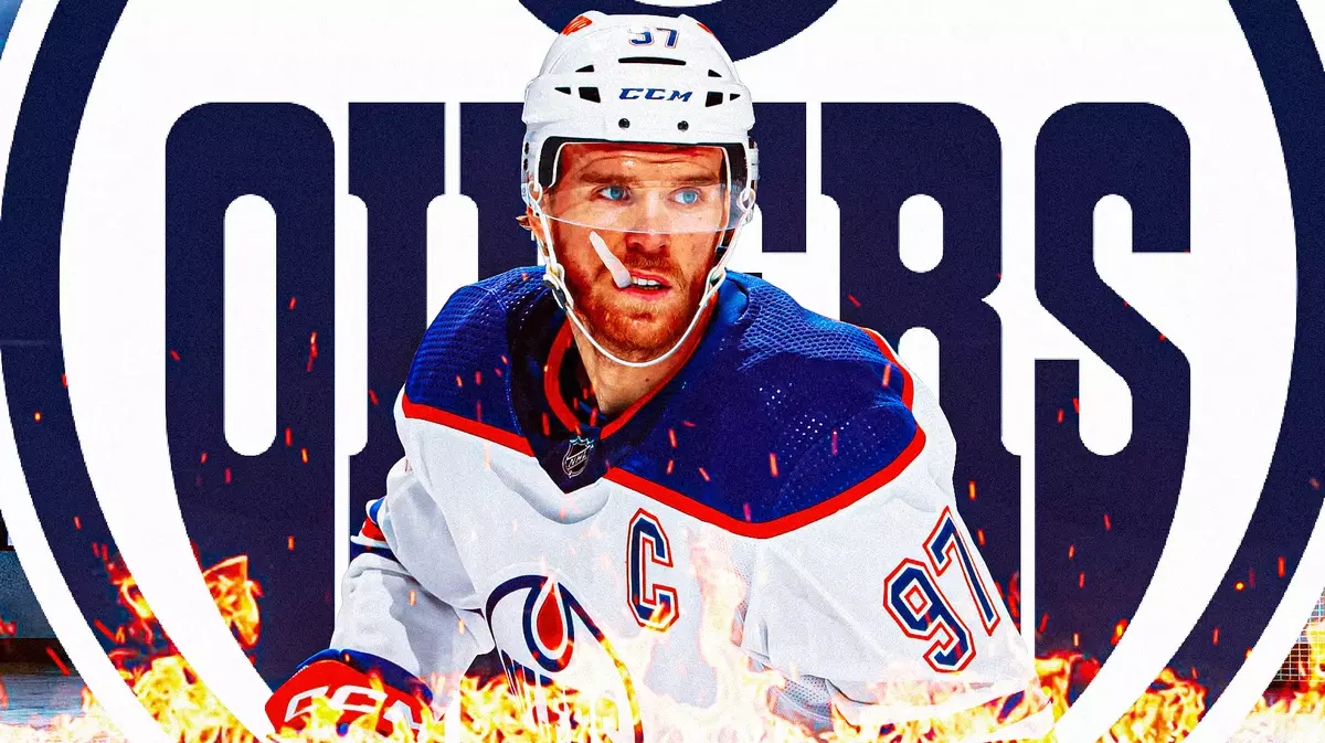 Connor McDavid in middle of image with fire around him looking happy, EDM Oilers logo in image, hockey rink in background