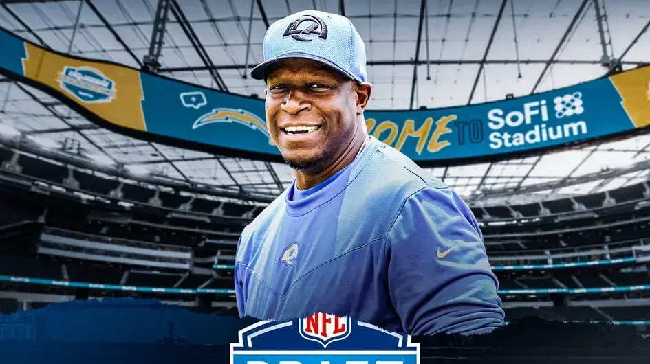 Former Rams DC Raheem Morris smiles after becoming the new Falcons coach, NFL Draft logo in the background