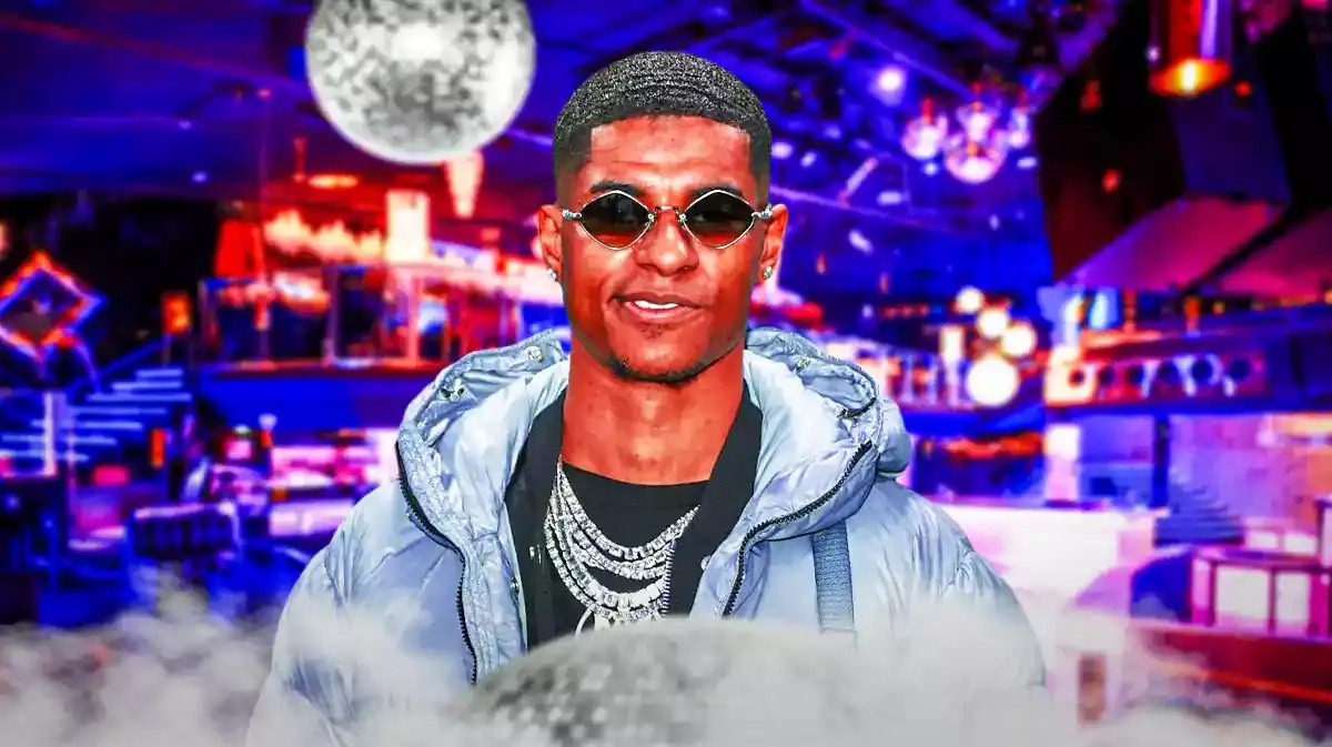Marcus Rashford in a club, the Manchester United logo on the wall