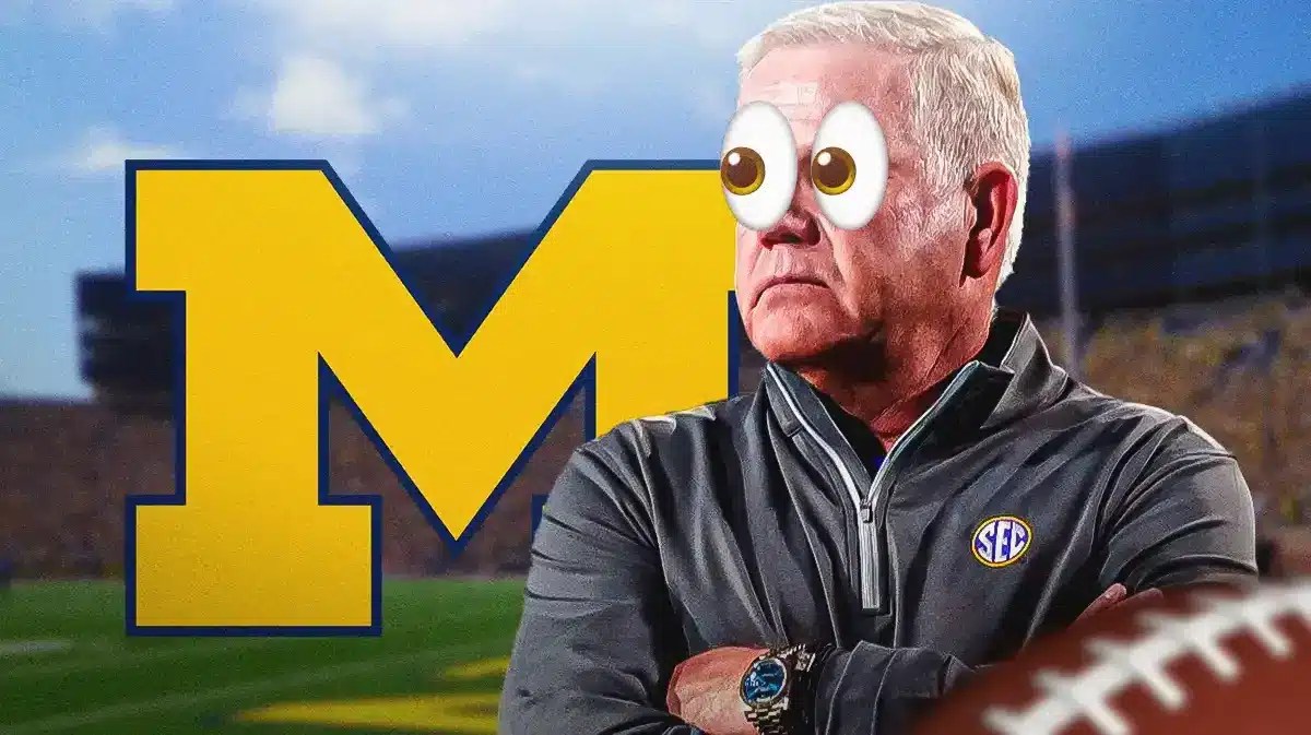 Brian Kelly next to Michigan foootball logo